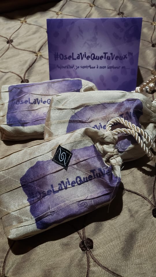 Une carte violette OseLaVieQueTuVeux derrière les pochettes qui contiennent les cartes